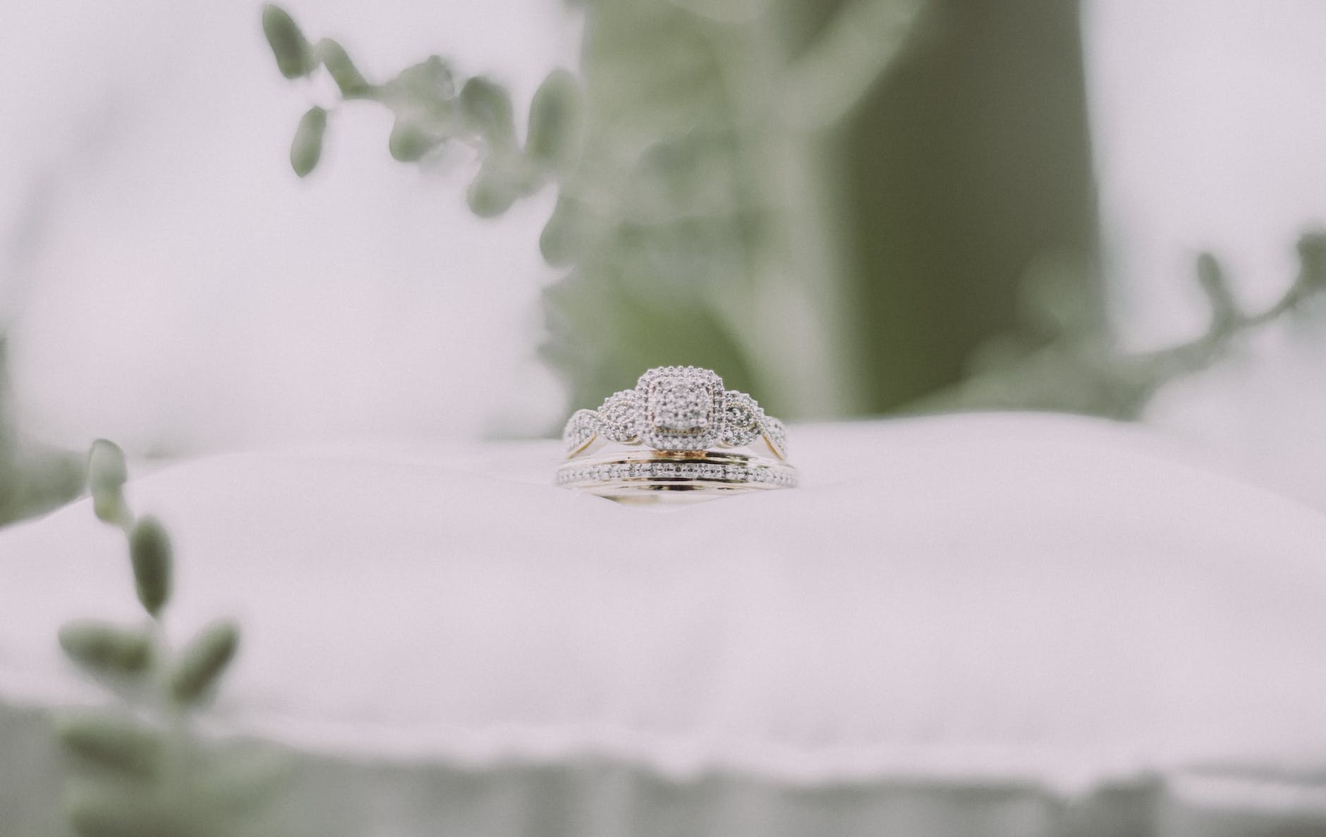 silver and gold ring on white textile