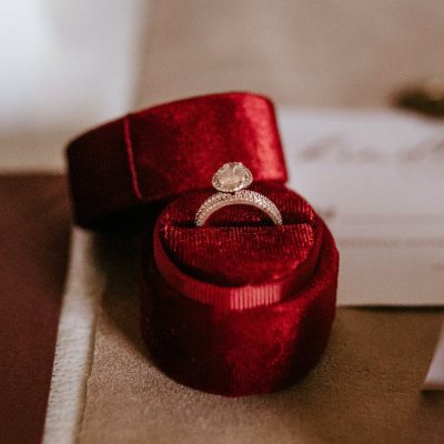 red box with golden ring placed on table with invitation cards