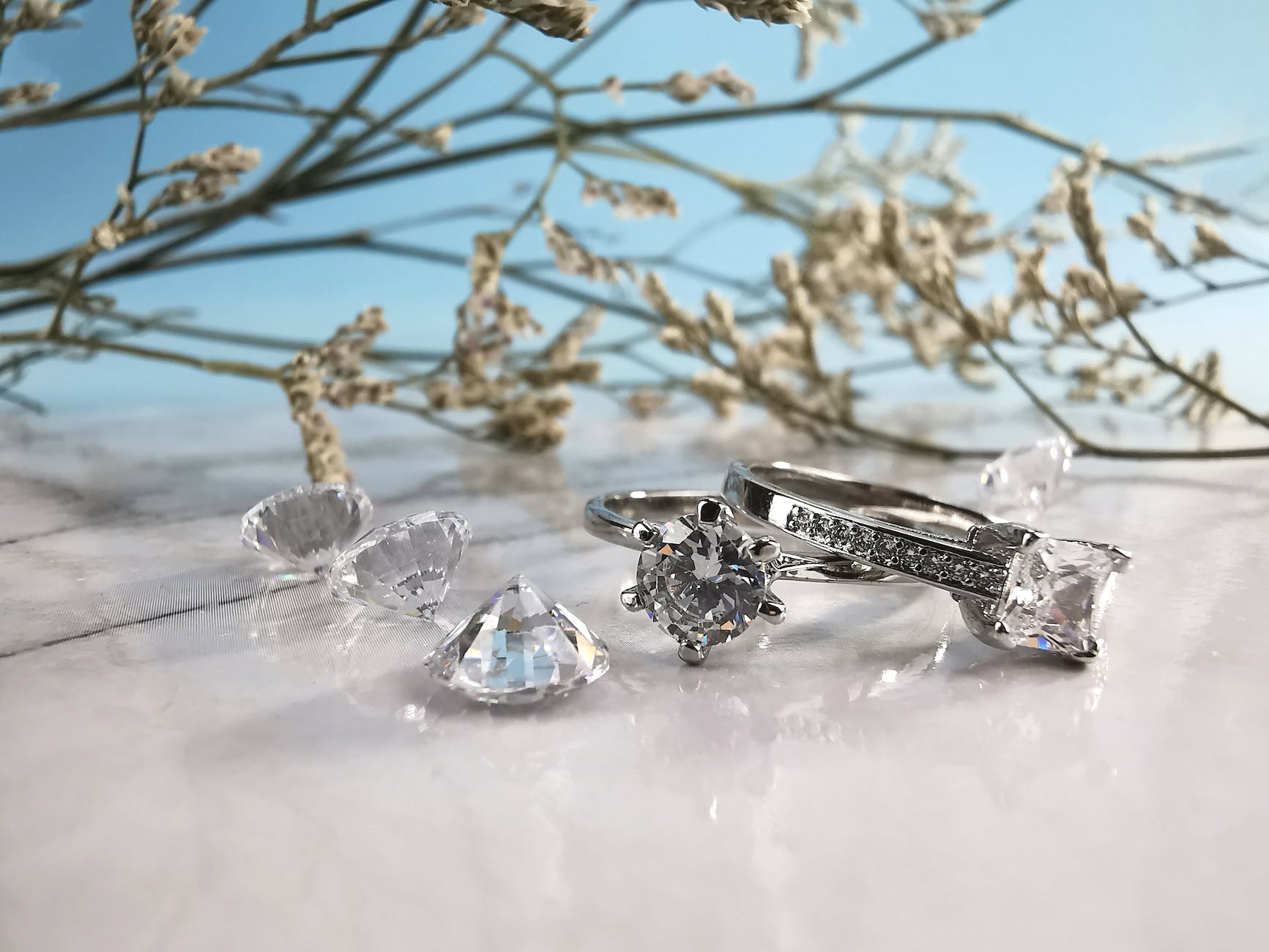 wedding rings and diamonds on white table